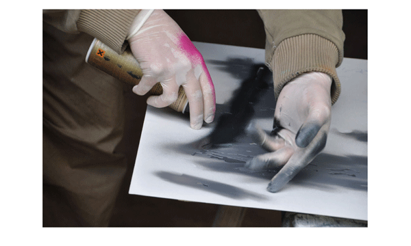 Artist doing a stencil graffiti